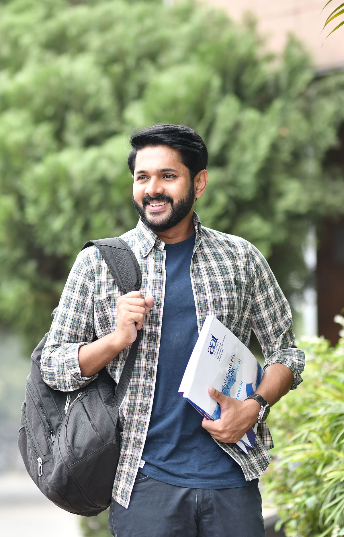 Smiling student carrying books and a backpack, representing youth aspiration and positive support for the Humara Baccha initiative